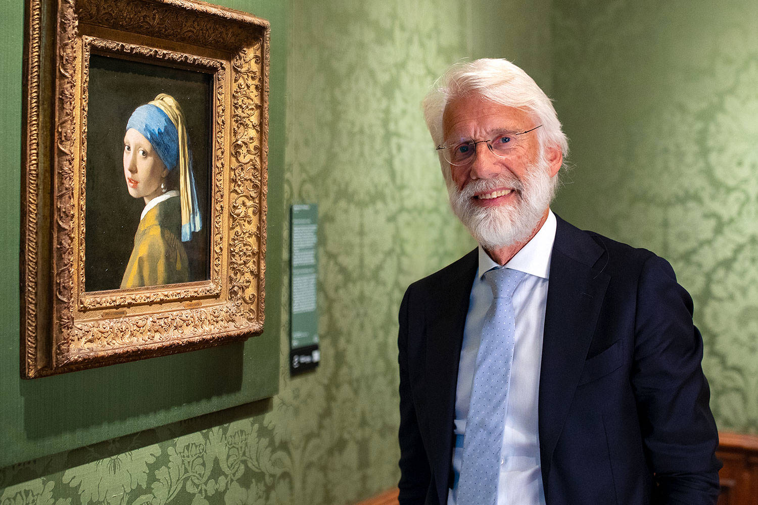 Neuro-onderzoeker Erik Scherder staat naast het Meisje met de parel van Johannes Vermeer in het Mauritshuis, Den Haag.