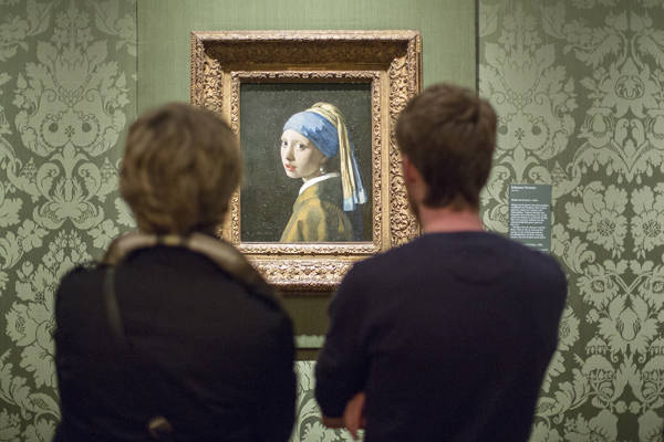 Bezoekers kijken naar het Meisje met de parel van Johannes Vermeer in het Mauritshuis, Den Haag.